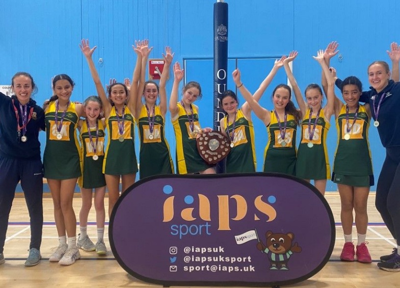 9 girls and their coaches Sophie Meister and Caitlin Rump hold the shield after winning U12 IAPS